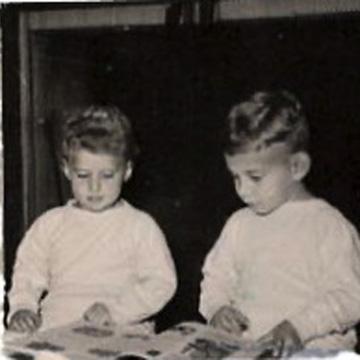 Black and white photo of toddlers Eric and Linda reading a magazine or newspaper
